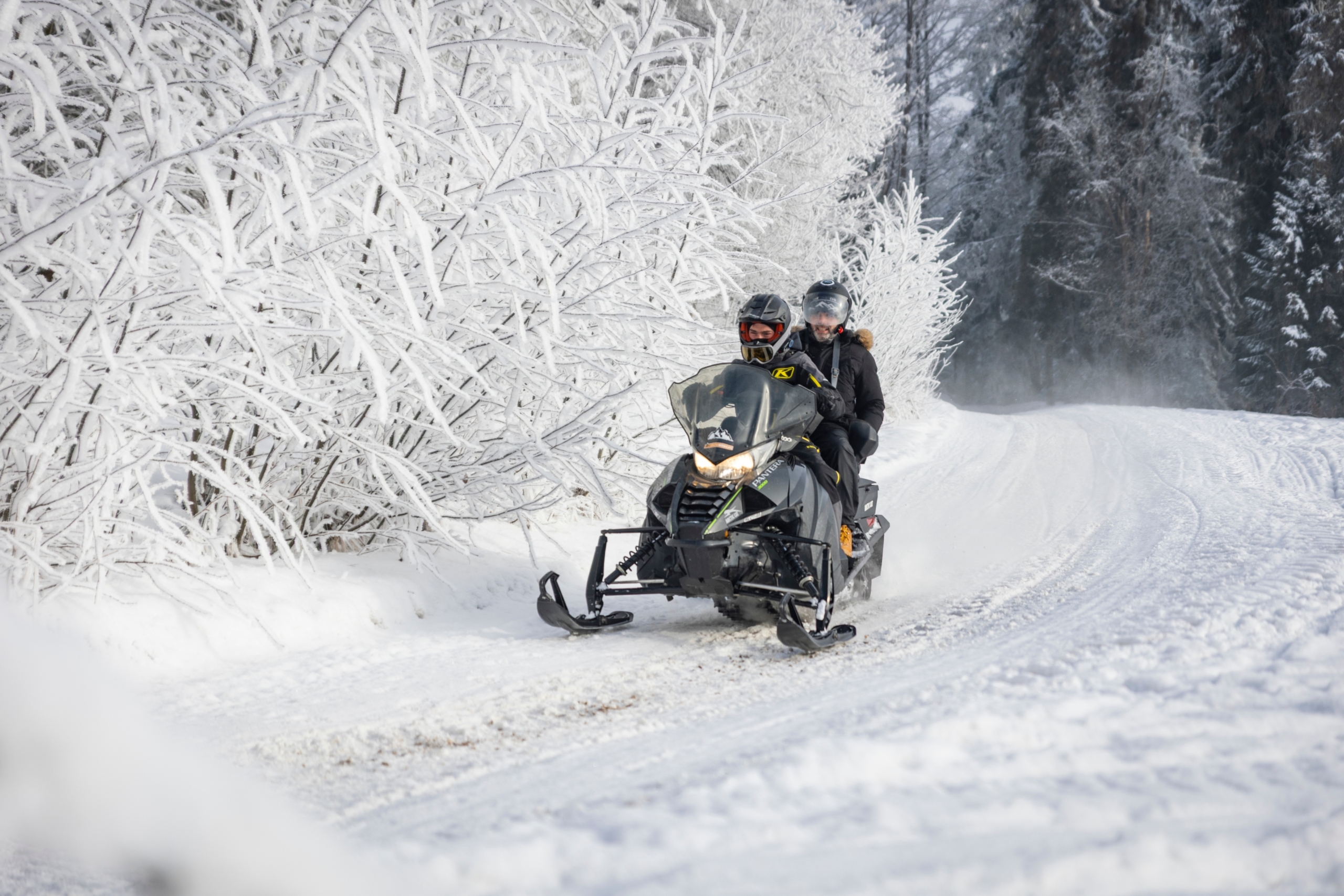 zakopane-snowmobile-tour-forest Zakopane Snowmobile Tour on a snowy forest trail with two riders