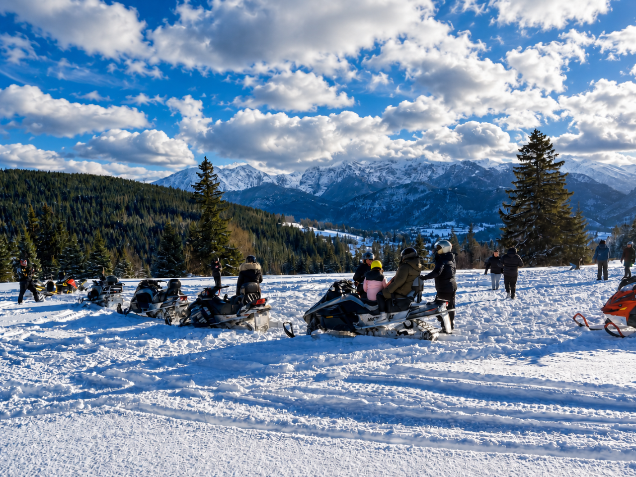 Snowmobile tour stop with a mountain view A group of snowmobiles parked in a snowy Zakopane clearing with tourists enjoying the view